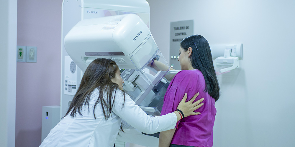 Doctora realizando examen de mamografía a paciente Doctora realizando examen de mamografía a paciente